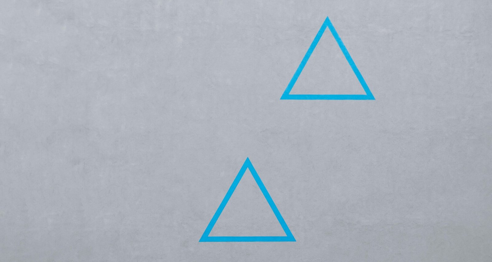 Zwei blaue, minimalistische Dreieckslogos auf dunklem Hintergrund als Symbol für modernes Branding und Design.