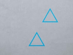 Zwei blaue, minimalistische Dreieckslogos auf dunklem Hintergrund als Symbol für modernes Branding und Design.