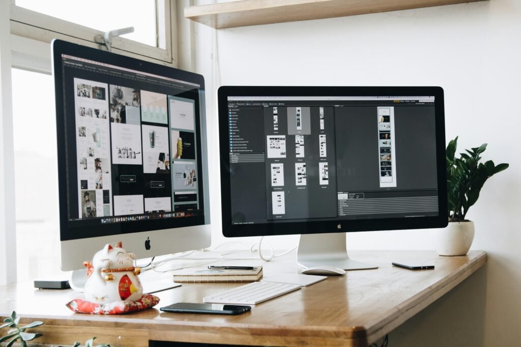 Zwei Computer-Monitore nebeneinander auf einem Holzschreibtisch für modernes Arbeiten im Büro oder Homeoffice