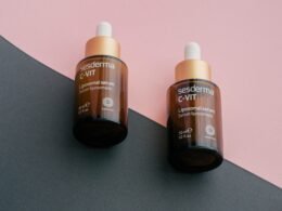 Zwei Gerania Vitamin C Flaschen stehen nebeneinander vor einem geteilten rosa und schwarzen Hintergrund.