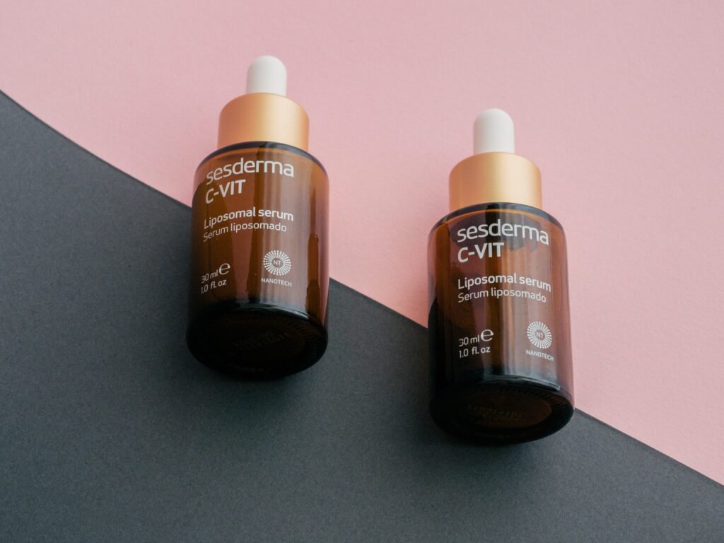 Zwei Flaschen Gerania Vitamin C auf einem geteilten rosa und schwarzen Untergrund, nebeneinander platziert