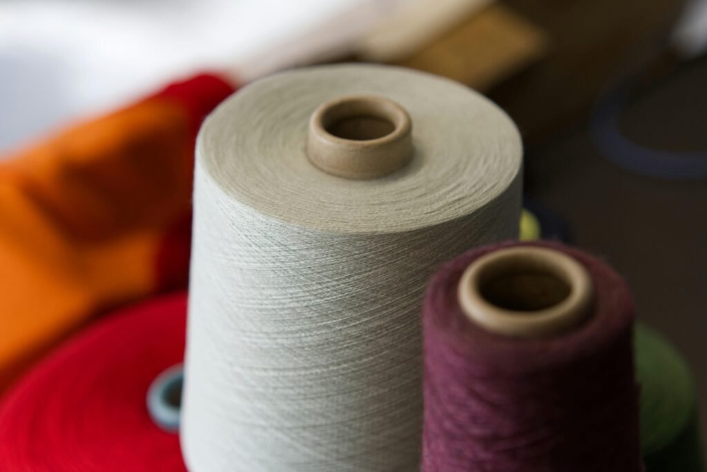 Zwei robuste Garnspulen aus nächster Nähe, nebeneinander platziert und für textile Arbeiten bereitgelegt