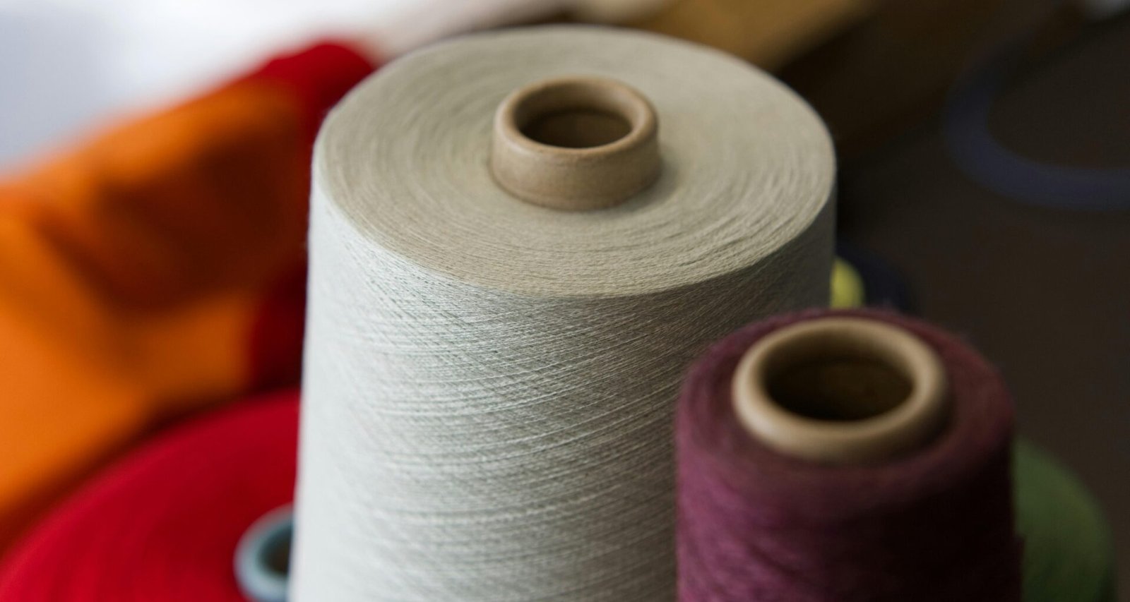 Zwei robuste Garnspulen aus nächster Nähe, nebeneinander platziert und für textile Arbeiten bereitgelegt