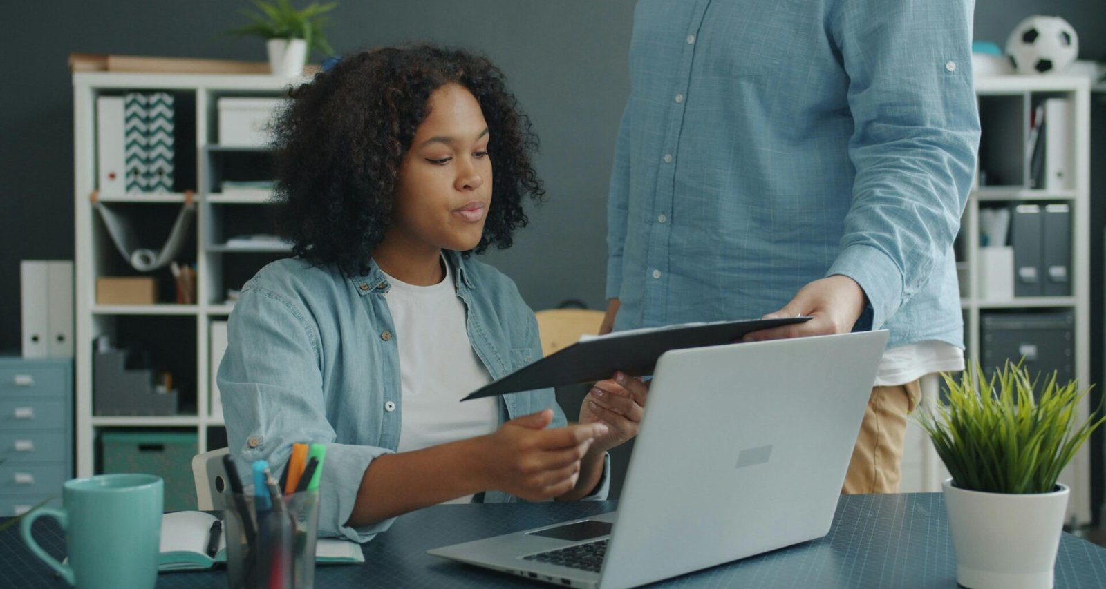 Zwei Kollegen analysieren Dokumente am Büroschreibtisch und besprechen gemeinsam die nächsten Schritte