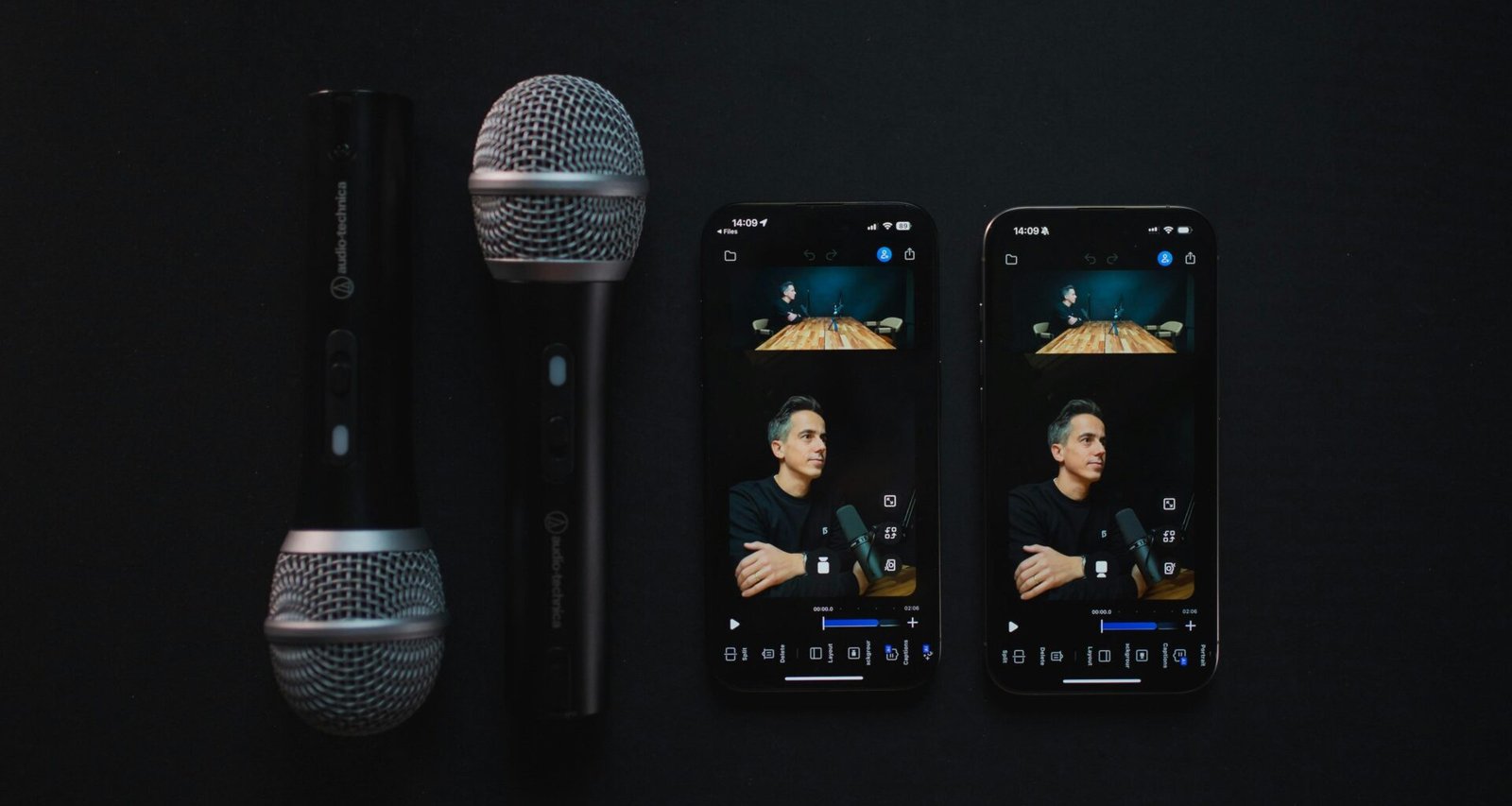 Zwei Podcast-Mikrofone und zwei Smartphones liegen auf einem Tisch und sind für eine Aufnahme bereitgestellt.