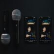 Zwei moderne Mikrofone und zwei Smartphones, die eine Podcast-Aufnahme auf einem Studio-Tisch zeigen