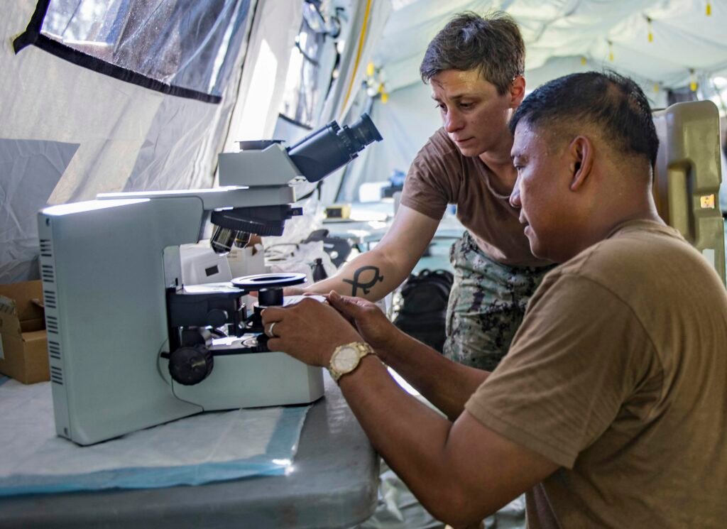 Zwei Personen nutzen ein Mikroskop im Labor, während sie an wissenschaftlichen Untersuchungen und Analysen arbeiten.