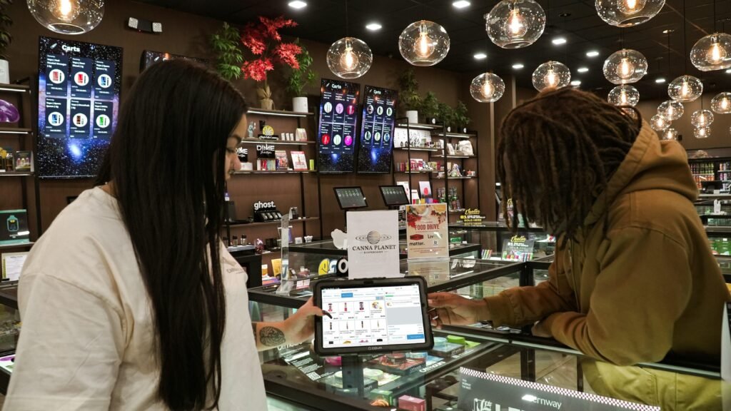 Zwei Menschen stehen an einem Tresen und bedienen gemeinsam ein Tablet, Fokus auf digitale Interaktion im Arbeitsumfeld.