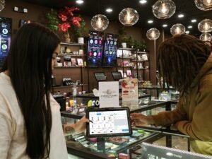 Zwei Menschen stehen an einem Tresen und bedienen gemeinsam ein Tablet, Fokus auf digitale Interaktion im Arbeitsumfeld.