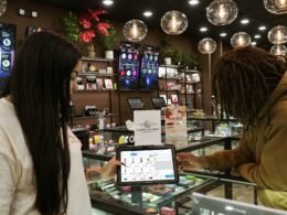 Zwei Personen stehen an einem Tresen und nutzen gemeinsam ein Tablet zur digitalen Interaktion in einem modernen Umfeld.