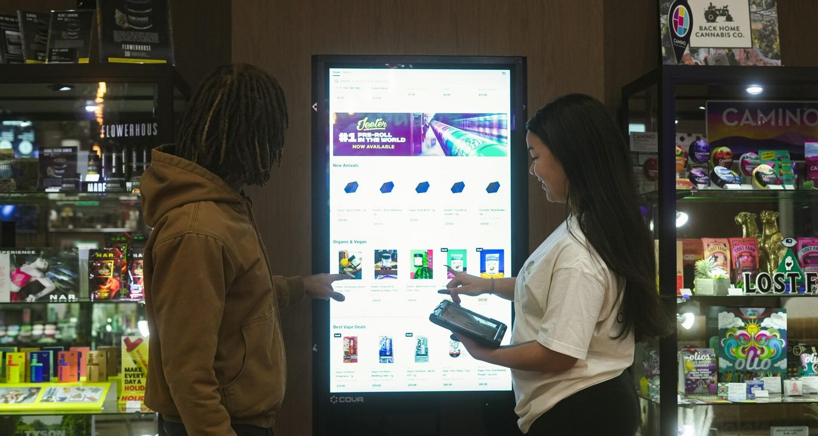 Zwei Personen bedienen gemeinsam einen digitalen Touchscreen, der Informationen anzeigt, modernes Arbeiten mit Displays.