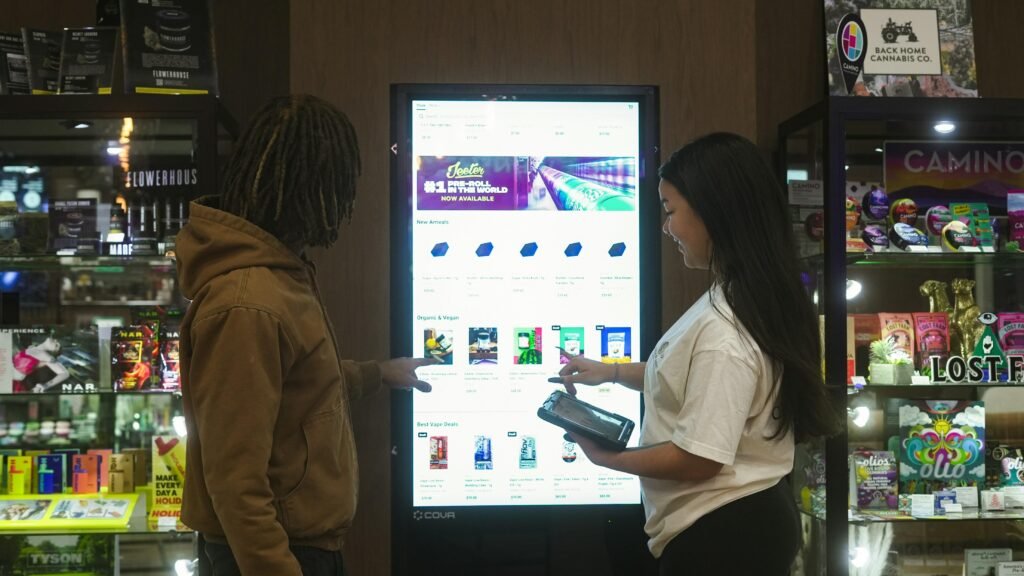 Zwei Personen bedienen gemeinsam einen digitalen Bildschirm und analysieren die dargestellten Informationen.