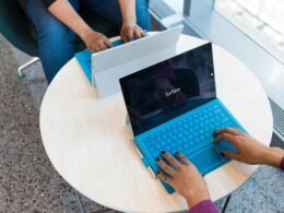 Zwei Personen sitzen gemeinsam am Schreibtisch und verwenden ein Microsoft Surface Tablet bei der Arbeit