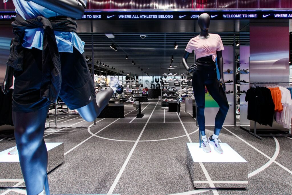Zwei Schaufensterpuppen tragen sportliche Kleidung in einem Geschäft und präsentieren aktuelle Trends im Sportmodebereich.