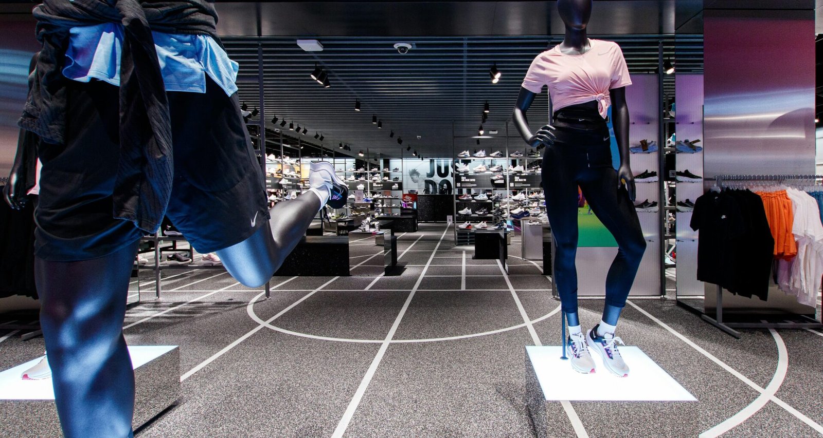 Zwei Schaufensterpuppen tragen sportliche Kleidung in einem Geschäft und präsentieren aktuelle Trends im Sportmodebereich.