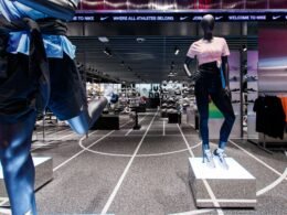 Zwei Schaufensterpuppen tragen sportliche Kleidung in einem Geschäft und präsentieren aktuelle Trends im Sportmodebereich.