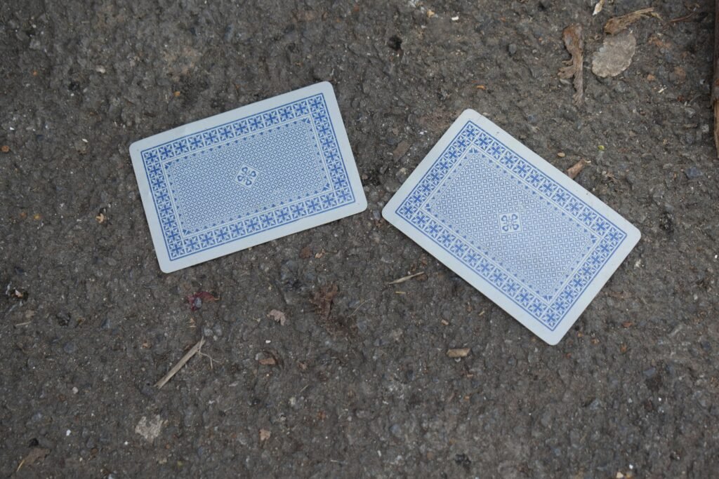 Zwei Spielkarten liegen nebeneinander auf einer rauen Oberfläche und verdeutlichen Glücksspiel und Strategie.