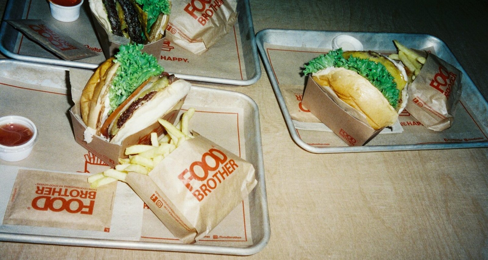 Zwei Tabletts mit verschiedenen Speisen stehen nebeneinander auf einem Holztisch in gemütlicher Atmosphäre.