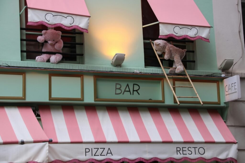 Zwei Teddybären sind auf einer Fassade eines Gebäudes angebracht und bilden einen auffälligen Hingucker im urbanen Umfeld.