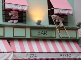 Zwei Teddybären sind auf einer Fassade eines Gebäudes angebracht und bilden einen auffälligen Hingucker im urbanen Umfeld.