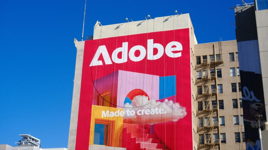Adobe Logo und Slogan deutlich sichtbar an der Außenfassade eines Geschäftsgebäudes aufgenommen