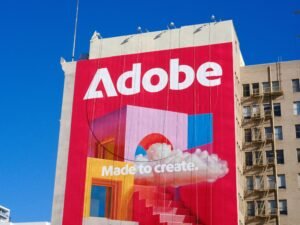 Adobe Logo und Slogan deutlich sichtbar an der Außenfassade eines Geschäftsgebäudes aufgenommen