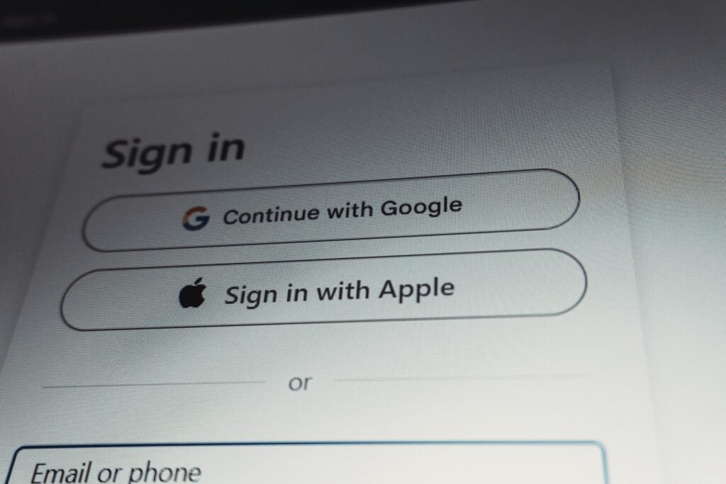 Login-Bildschirm mit Auswahl zwischen Google- und Apple-Konto als Anmeldeoptionen, fotografiert von Zulfugar Karimov