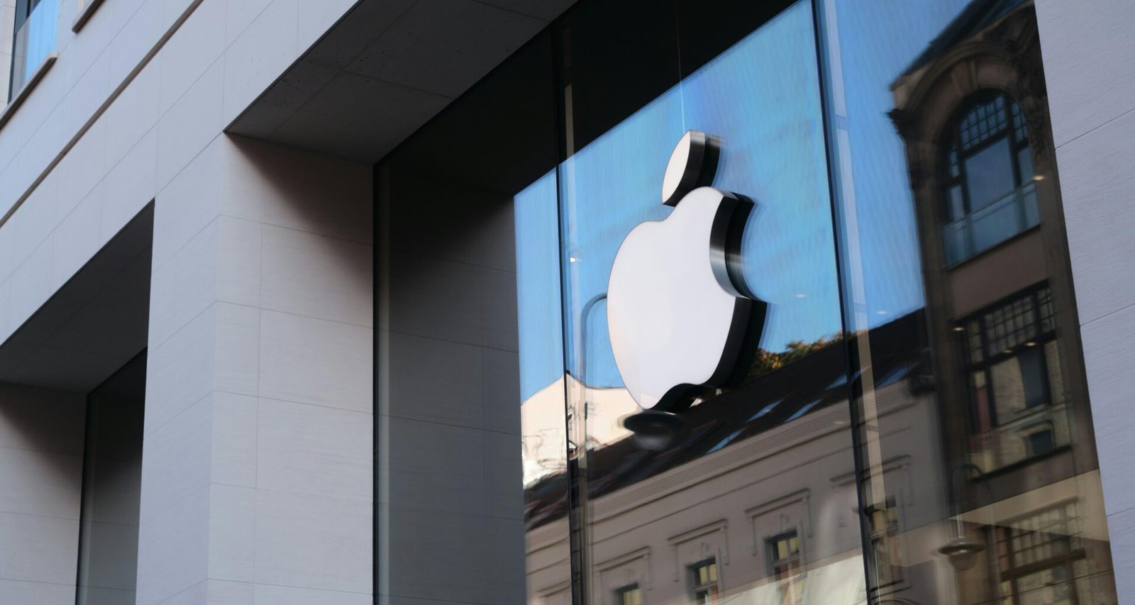 Reflexion des Apple Logos in den Fenstern eines modernen Bürogebäudes bei Tageslicht, aufgenommen von appshunter.io