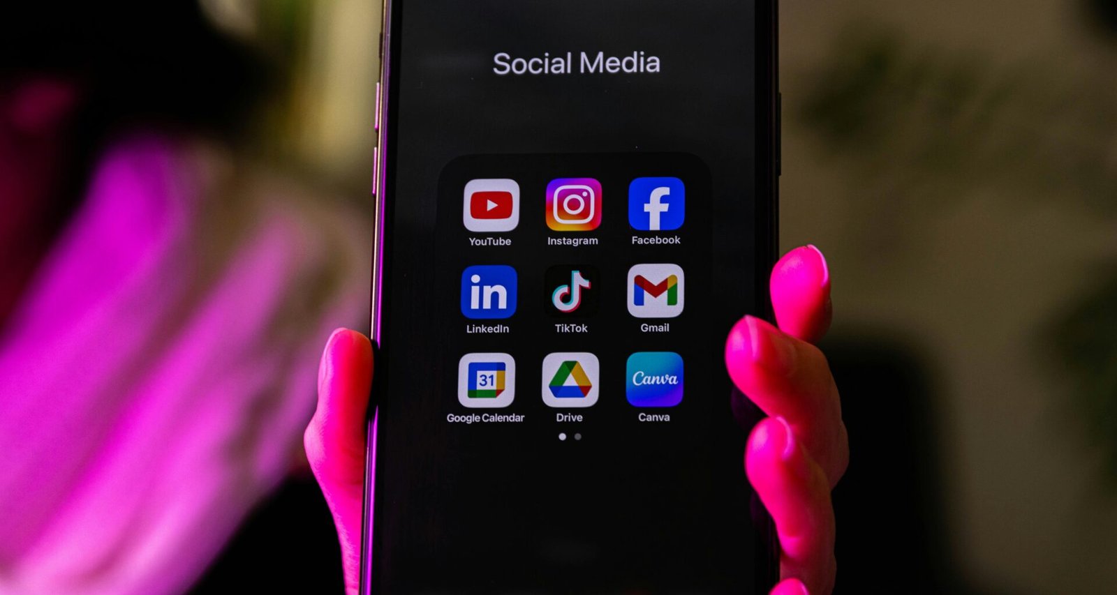 Ein Smartphone, auf dessen Bildschirm verschiedene Social Media App-Symbole abgebildet sind, liegt auf einer Oberfläche.