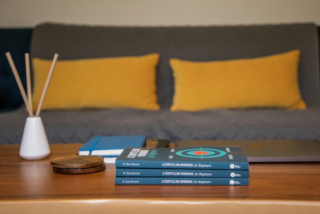 Blaues und gelbes Buch liegt auf braunem Holztisch, ideal für Beiträge rund um Wissen und Arbeitsumgebung.