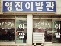 Braunes und weißes Geschäft aus Holz mit großen Fenstern, aufgenommen aus der Straßenperspektive