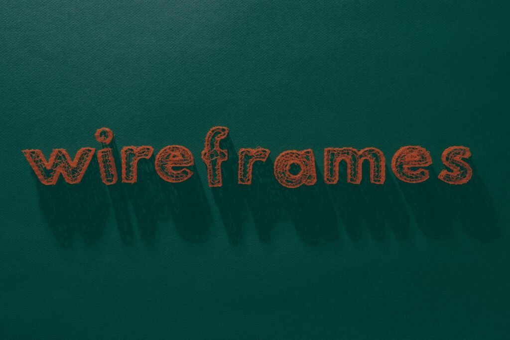 Das Wort 'Wireframes' steht weiß geschrieben auf einer grünen, strukturierten Oberfläche – Symbol für Webdesign-Prozesse.