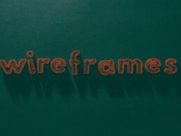 Das Wort 'Wireframes' steht weiß geschrieben auf einer grünen, strukturierten Oberfläche – Symbol für Webdesign-Prozesse.