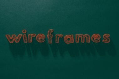Das Wort 'Wireframes' steht weiß geschrieben auf einer grünen, strukturierten Oberfläche – Symbol für Webdesign-Prozesse.