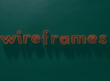 Das Wort 'Wireframes' steht weiß geschrieben auf einer grünen, strukturierten Oberfläche – Symbol für Webdesign-Prozesse.