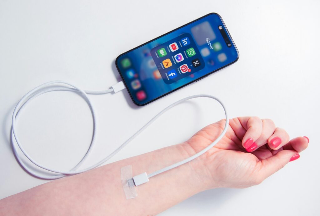 Nahaufnahme eines weiblichen Arms, der ein Smartphone hält, an das ein Ladegerät angeschlossen ist.