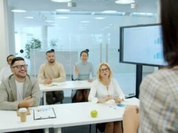 Menschen sitzen in einem Konferenzraum und hören aufmerksam einer Business-Präsentation zu, Fokus auf Zusammenarbeit.