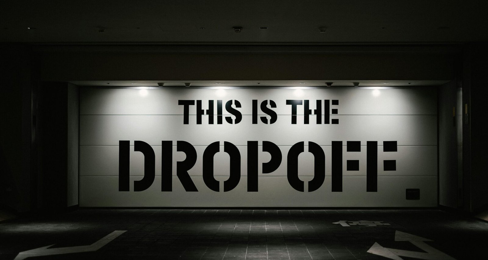 Im Dunkeln leuchtendes Dropoff-Schild auf einem Parkplatz, aufgenommen aus der Nähe, mit Fokus auf die Beschriftung