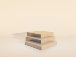 Drei beige farbene Würfel stehen aufeinander gestapelt auf einem schlichten Hintergrund ohne weitere Elemente.
