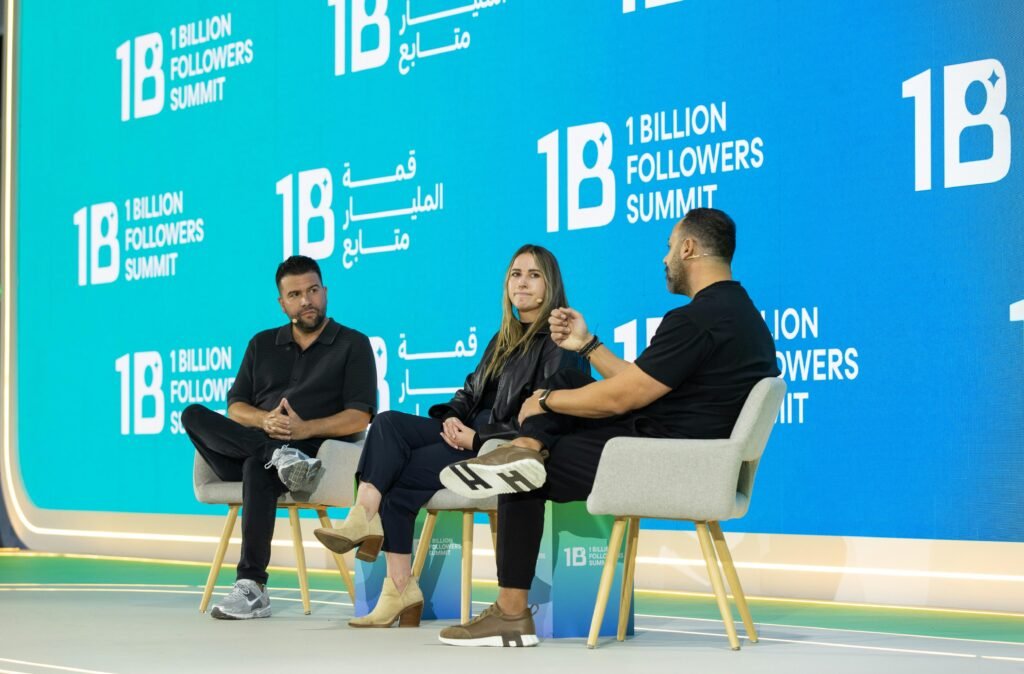 Drei Menschen sitzen auf einer Bühne in einer Paneldiskussion und tauschen sich über digitale Themen aus