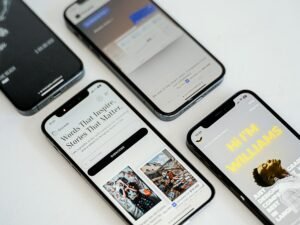 Drei verschiedene Smartphones liegen nebeneinander auf einer Oberfläche und zeigen moderne Designs und Displaygrößen.