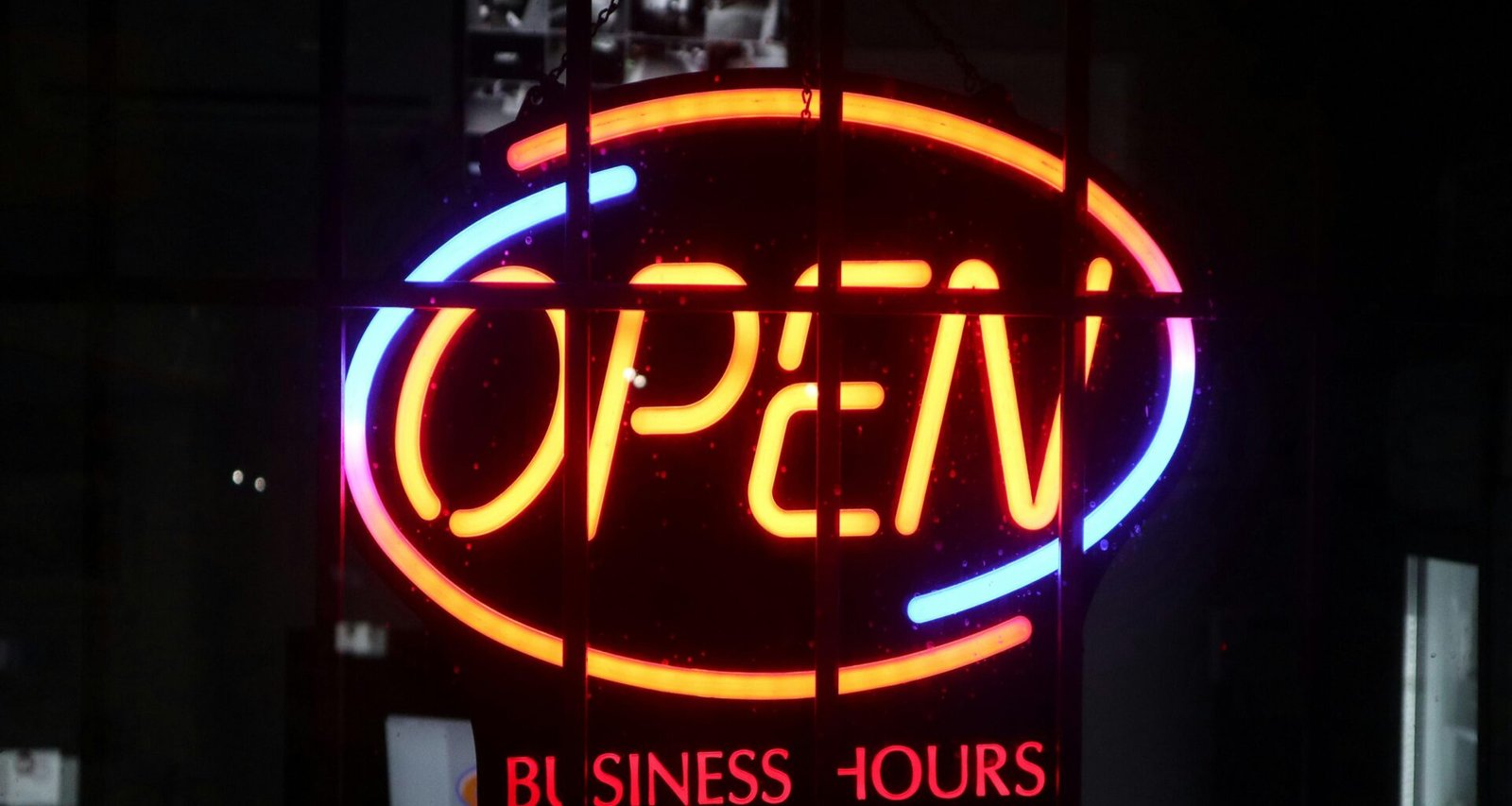 Ein beleuchtetes Schild mit deutlich sichtbarem Schriftzug, fotografiert in urbaner Umgebung, Fokus auf Design und Lichttechnik.