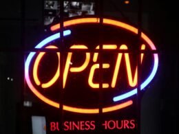 Beleuchtetes Schild mit einem einzelnen Wort auf dunklem Hintergrund aus moderner Indoor-Umgebung