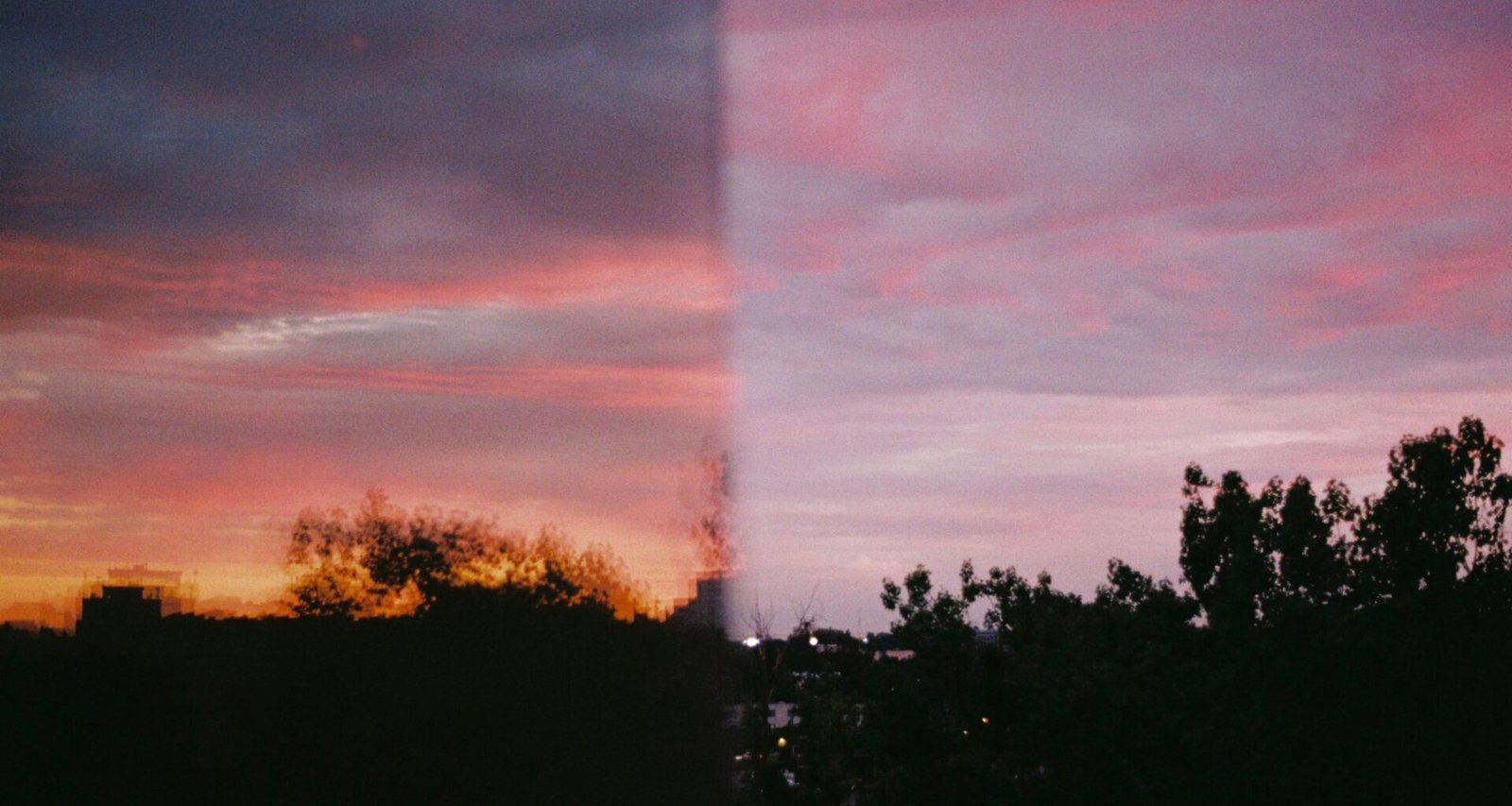 Sonnenuntergang hinter einem Fenster fotografiert, mit Spiegelungen und deutlichen Konturen im Rahmen