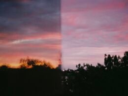 Sonnenuntergang hinter einem Fenster fotografiert, mit Spiegelungen und deutlichen Konturen im Rahmen