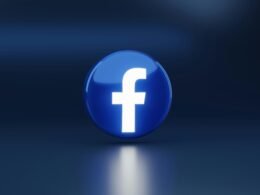 Ein modernes, blaues Logo mit einem weißen Kreuz, fotografiert vor neutralem Hintergrund – Inspiration für Webdesign und Branding