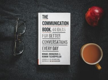 Offenes Buch auf einem Holz­tisch mit Kaffee­tasse daneben, ideale Szene für Arbeit oder Lesezeit im Büro oder Homeoffice.