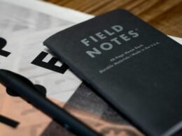 Offenes Buch mit einem Stift auf dem Einband, das für Notizen, Planung und Organisation genutzt werden kann.