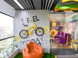 Offenes, modern eingerichtetes Büro mit einem an der Wand montierten Fahrrad und Arbeitsplätzen im Vordergrund