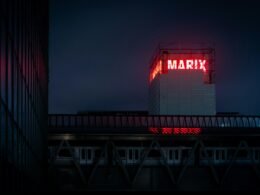 Ansicht eines modernen Gebäudes mit einem markanten Schild an der Fassade, aufgenommen bei Tageslicht.